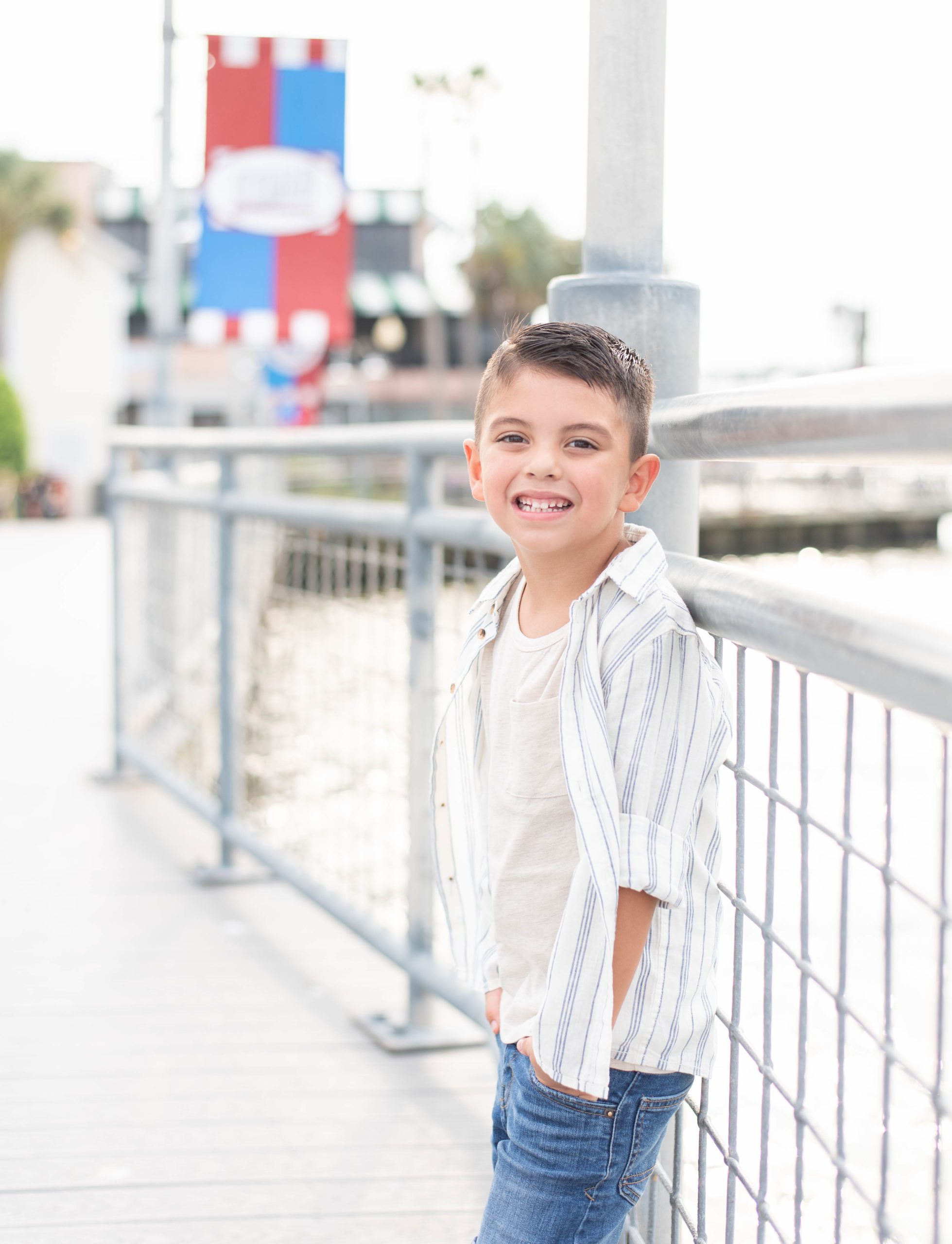young boy smiles on the pier at the kemah boardwalk